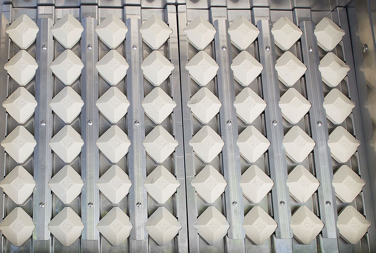 Row of gray square knobs or caps arranged in a grill component